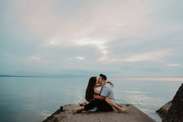 Beach engagement photos at Sunset Beach in St. Catharines, Ontario two brides casual clothing Canada kissing