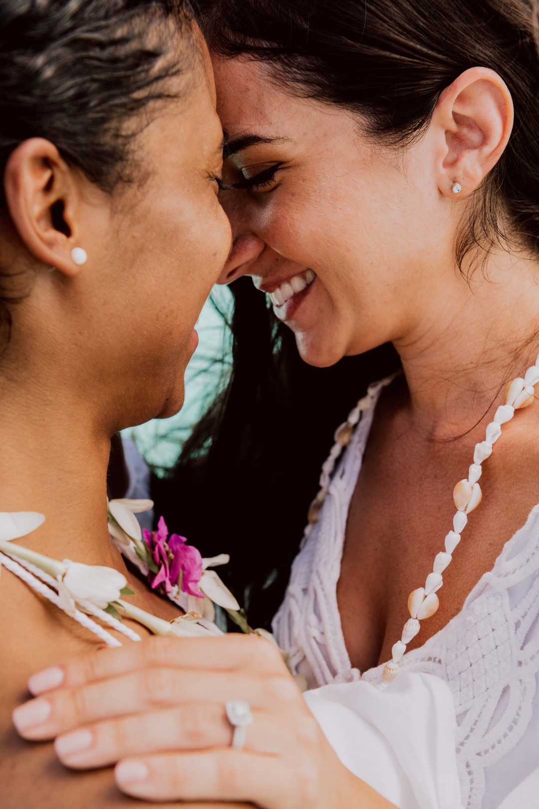 Beach honeymoon photos in Bora Bora two brides white dresses clear blue oceans palm trees