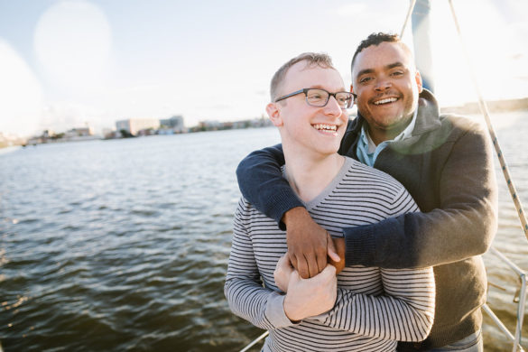 Boat rides and dog walks during loving Baltimore engagement photos two grooms boat water