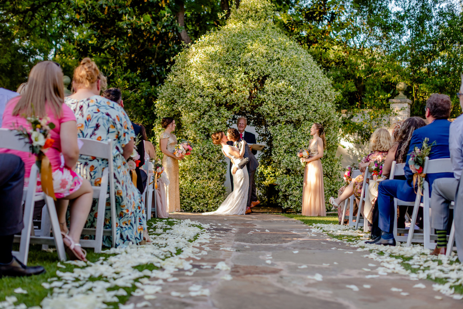 Colorful, whimsical spring backyard wedding in Austin, Texas two brides white dress black tux kiss