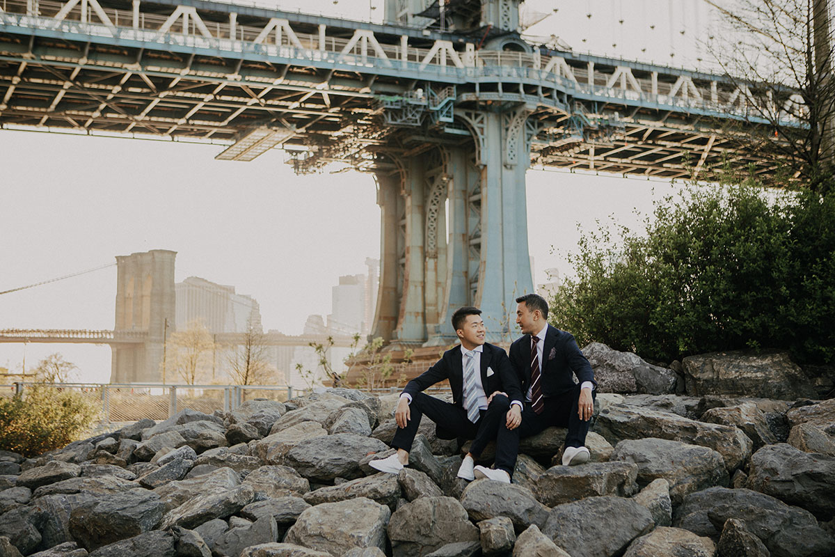Elegant, fun engagement photos at Central Park with rainbow bubbles two grooms purple tux blue tux bow ties Brooklyn Bridge