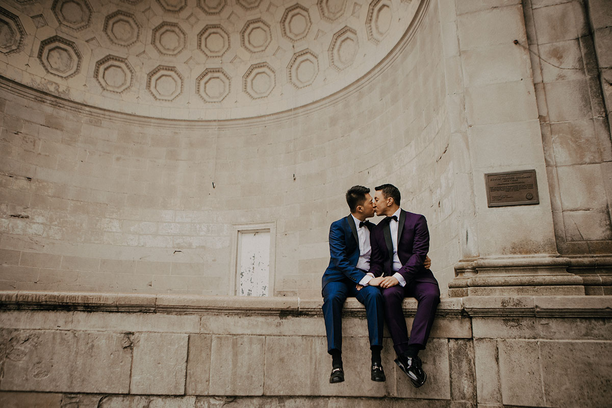 Elegant, fun engagement photos at Central Park with rainbow bubbles two grooms purple tux blue tux bow ties kiss