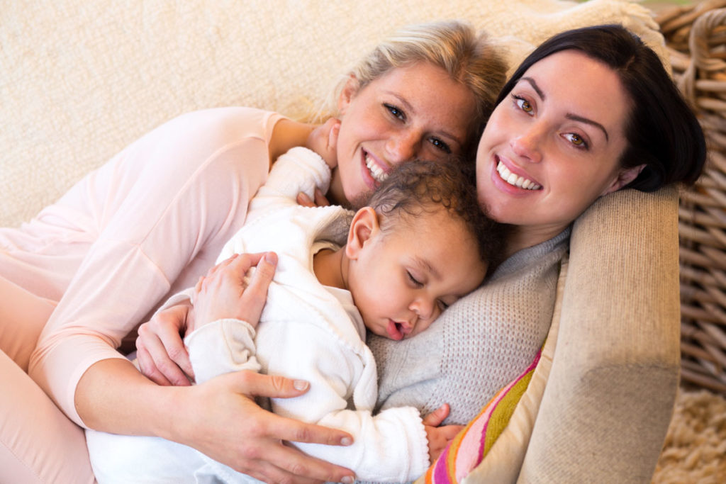 Female couple cuddling with their baby son LGBTQ+ family planning: be the parents you’ve always dreamed of with the help of Cryos