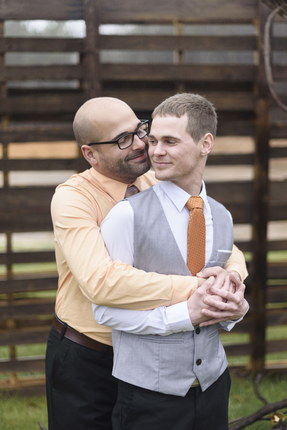 Orange winter elopement inspiration two grooms February wedding hug