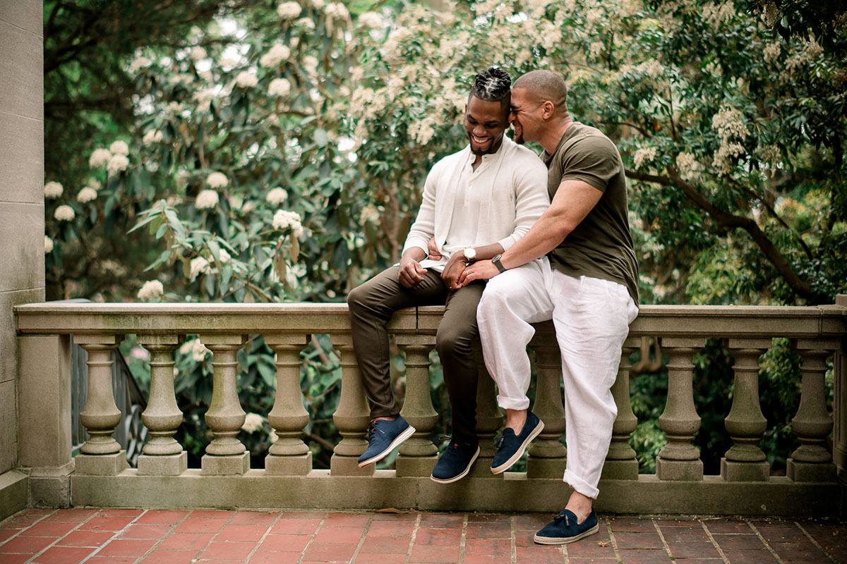 Vibrant, affectionate Van Vleck House and Gardens engagement photos two grooms outside Montclair New jersey cuddling