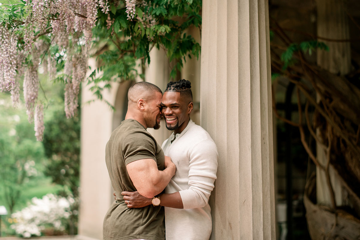 Vibrant, affectionate Van Vleck House and Gardens engagement photos two grooms outside Montclair New jersey cuddling