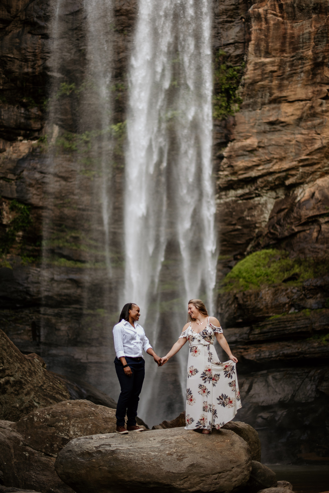 Waterfall adventure engagement photos at Toccoa Falls two brides fun holding hands