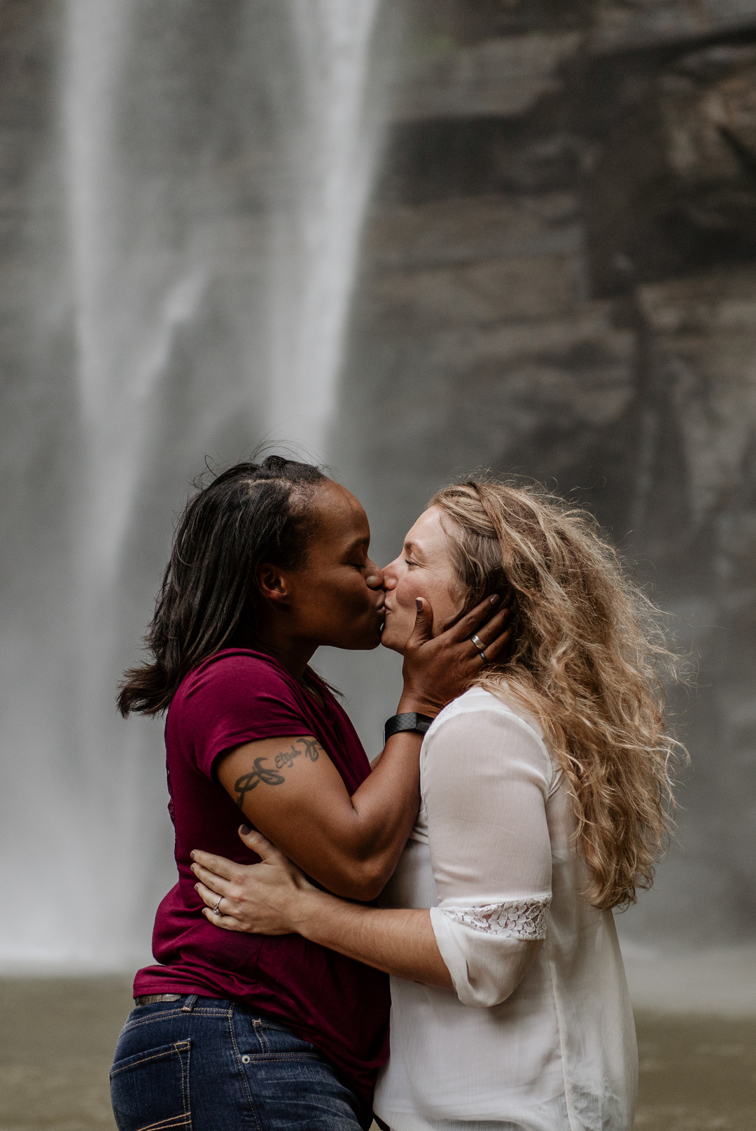 Waterfall adventure engagement photos at Toccoa Falls two brides fun kiss