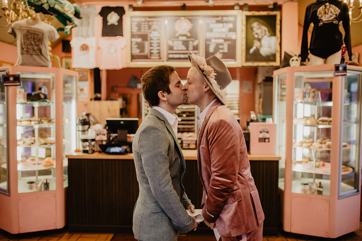 Bohemian hipster elopement inspiration at Voodoo Doughnut LGBTQ+ weddings two grooms rose gold pink cream teal Portland Oregon kiss