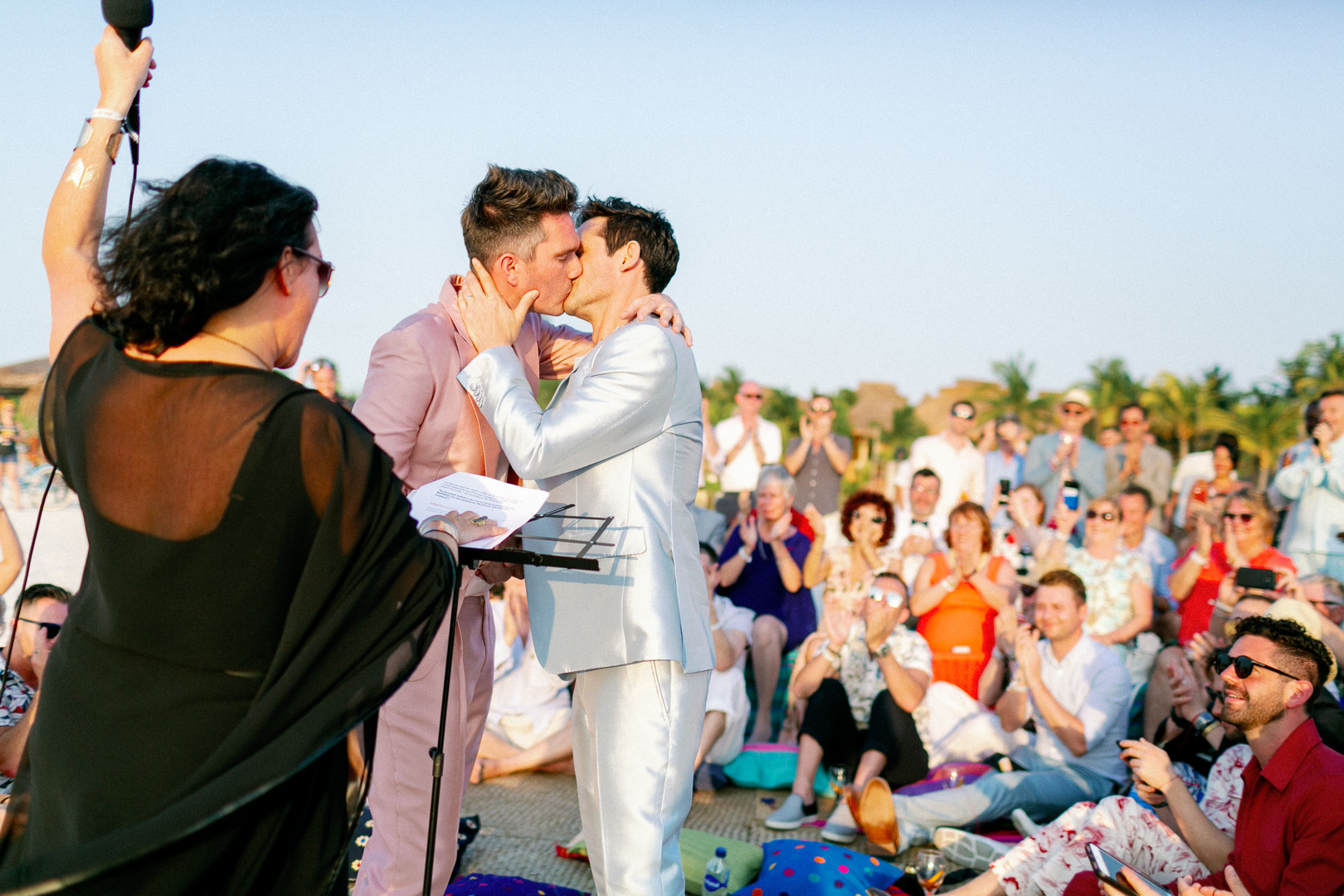 Chic bohemian beach Lucha Libre themed wedding LGBTQ+ weddings light baby blue tux pink tux colorful Mexican destination gay wedding two grooms kiss vows