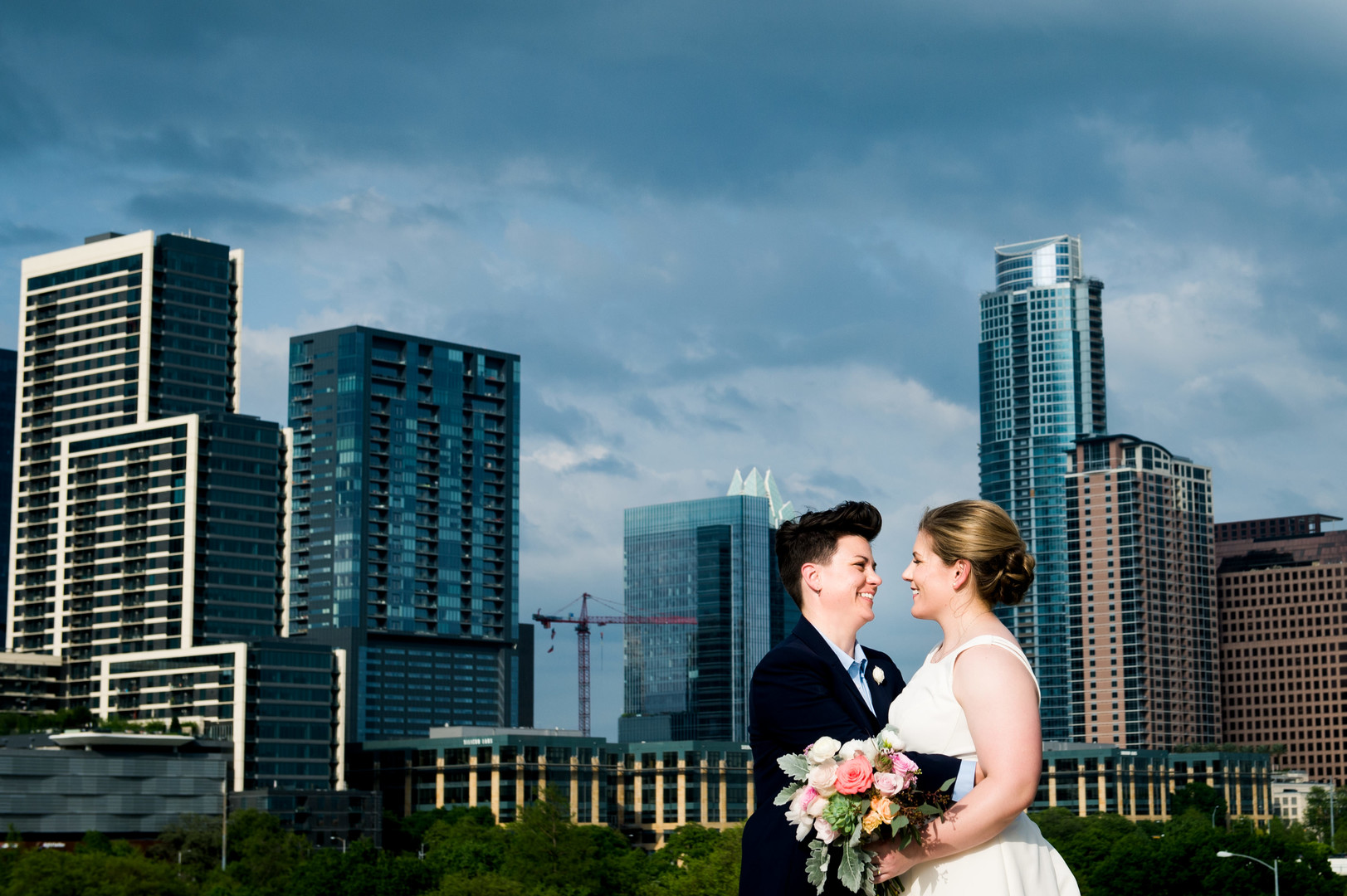 Intimate spring wedding at Butler Park in Austin, Texas LGBTQ+ weddings lesbian wedding two brides white dress navy blue suit skyline