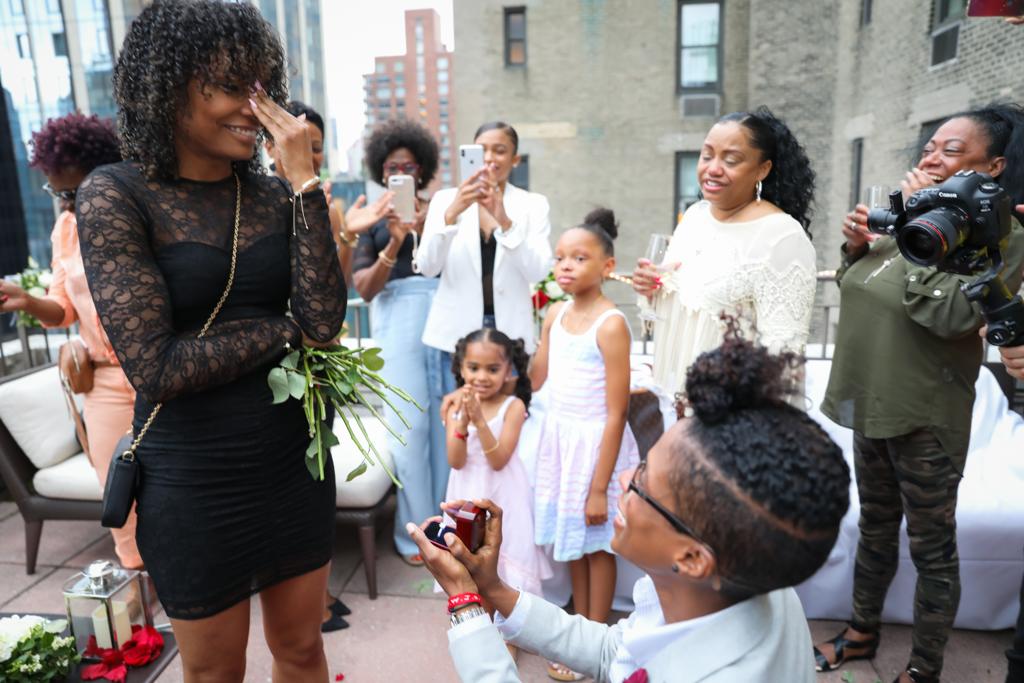 Surprise proposal at the Benjamin Hotel in New York City, New York LGBTQ+ weddings rooftop party engagement propose