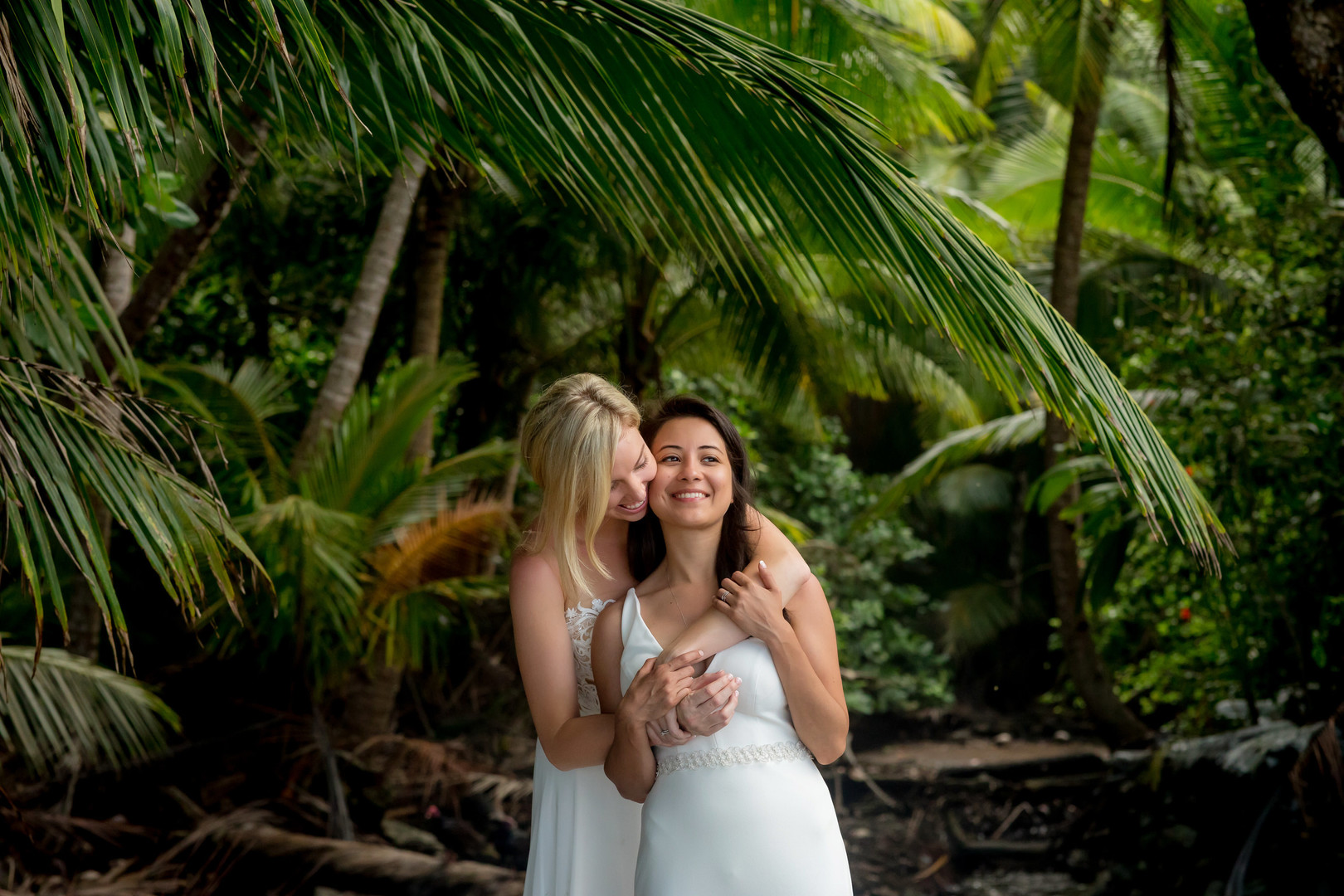 This couple needed a rain plan for their Costa Rica destination wedding LGBTQ+ weddings destination wedding two brides white dresses beach ocean palm tress