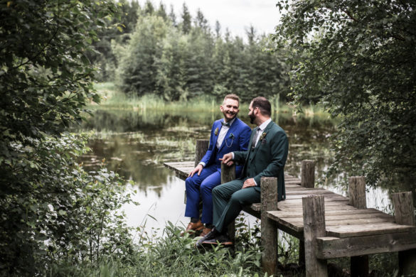 This elegant, enchanted forest wedding has the magical vibes you need LGBTQ+ weddings moody romantic two grooms gay wedding tuxedos woods docks sitting