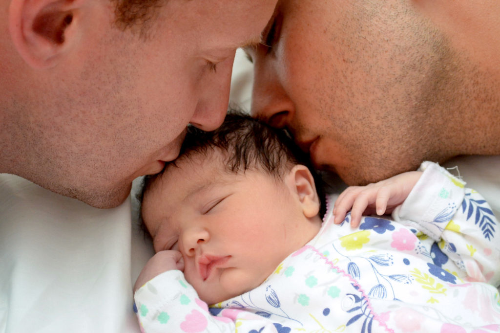 LGBTQ+ dads Derek Mize and Jonathan Gregg with their daughter Simone via immigrationequality.org