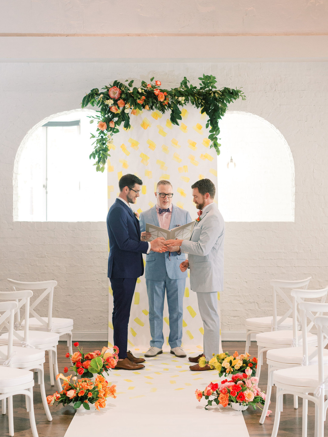 Summer citrus wedding inspiration at historic post office LGBTQ+ weddings two grooms gay wedding blue suit white gray suit orange blue bright colorful summery styled shoot vows