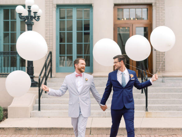 Summer citrus wedding inspiration at historic post office LGBTQ+ weddings two grooms gay wedding blue suit white gray suit orange blue bright colorful summery styled shoot balloons