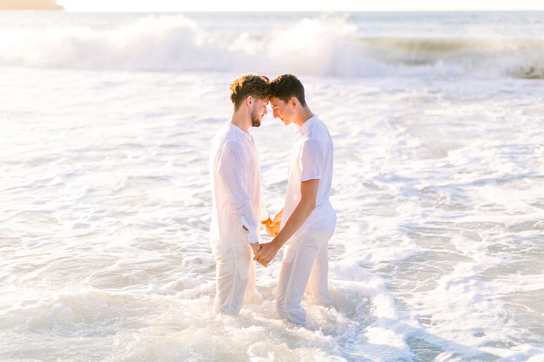 Romantic engagement photos on the beach in Kauai, Hawaii LGBTQ+ weddings engaged two grooms gay engagement photos water ocean