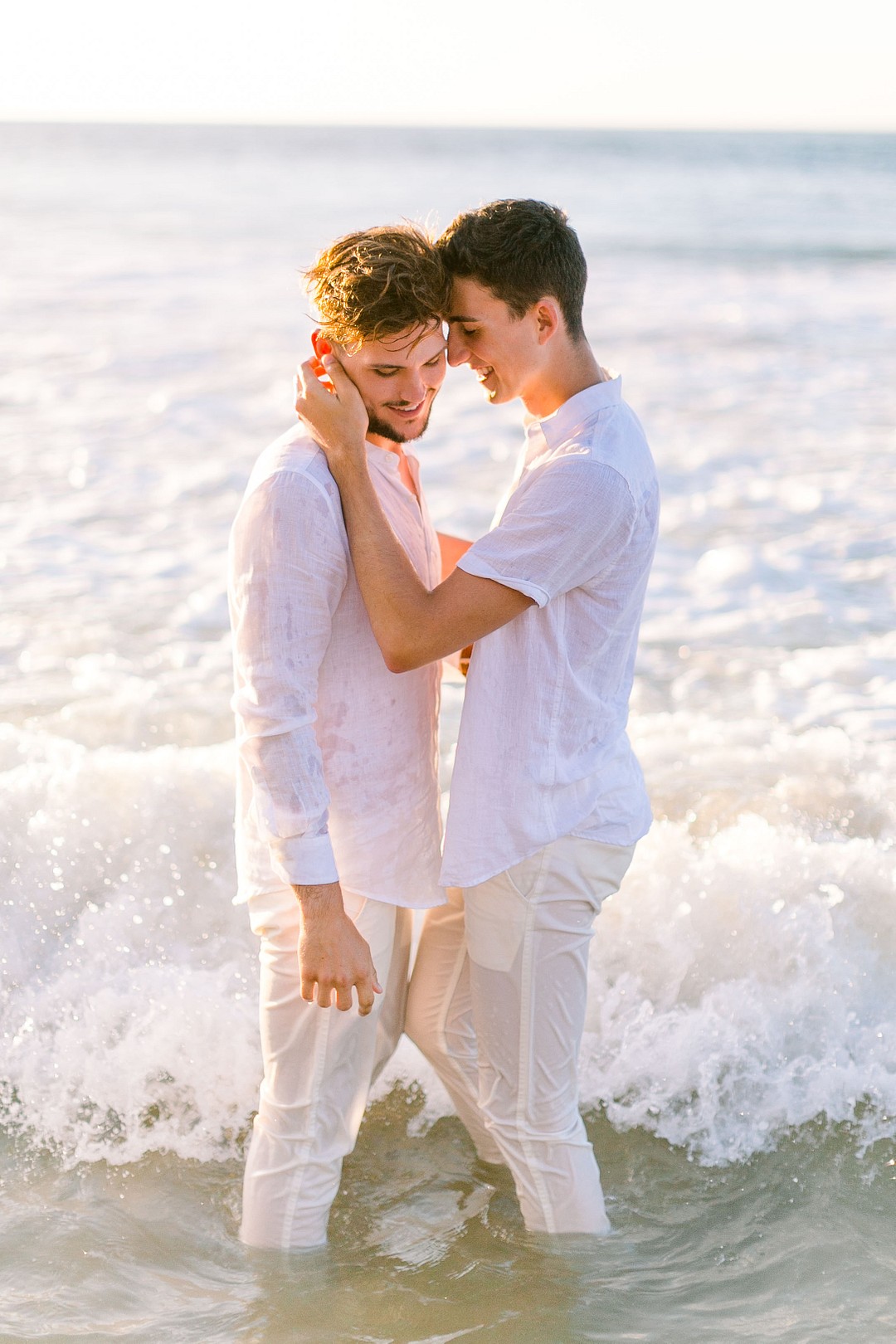 Romantic engagement photos on the beach in Kauai, Hawaii LGBTQ+ weddings engaged two grooms gay engagement photos water ocean