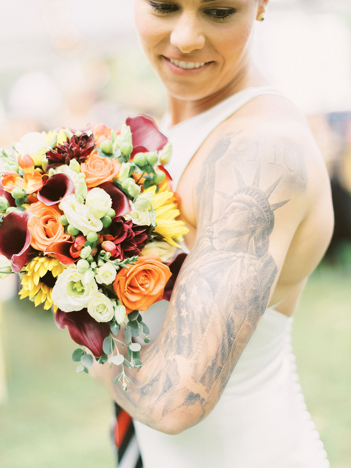 Rustic orange and yellow autumn wedding in Norfolk, MA LGBTQ+ weddings mrs. and mrs. two brides lesbian wedding fall autumn cozy New England state of liberty tattoo