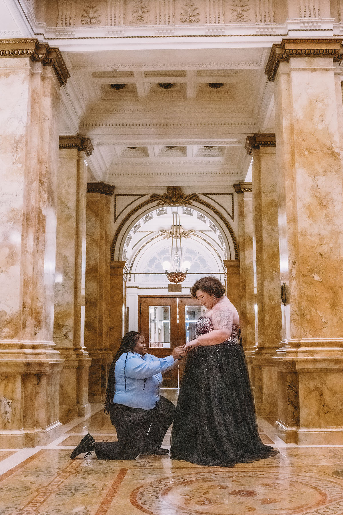 Romantic engagement photos at Milwaukee Central Public Library two brides tulle and glitter dress proposal