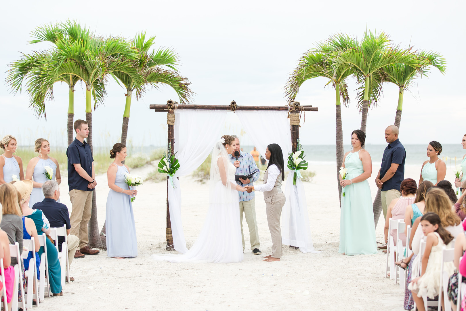 Tropical blue and green beach wedding in St. Petersburg, Florida two brides lesbian wedding white dress tan suit destination LGBTQ+ weddings vows