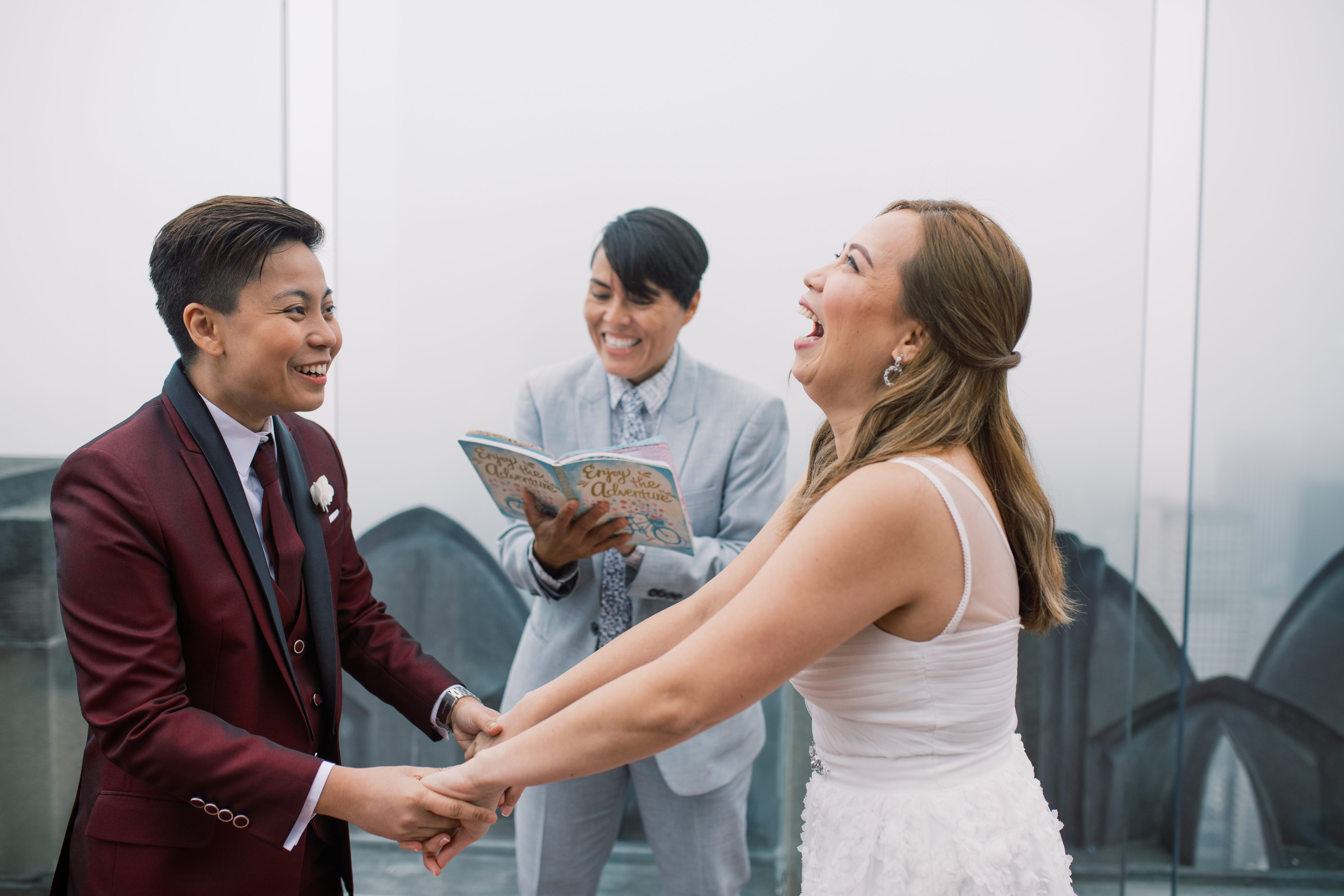 Romantic spring elopement at The Top of The Rock in New York City wine cranberry suit white dress New York City NYC two brides LGBTQ+ weddings lesbian gay wedding transcontinental destination vows