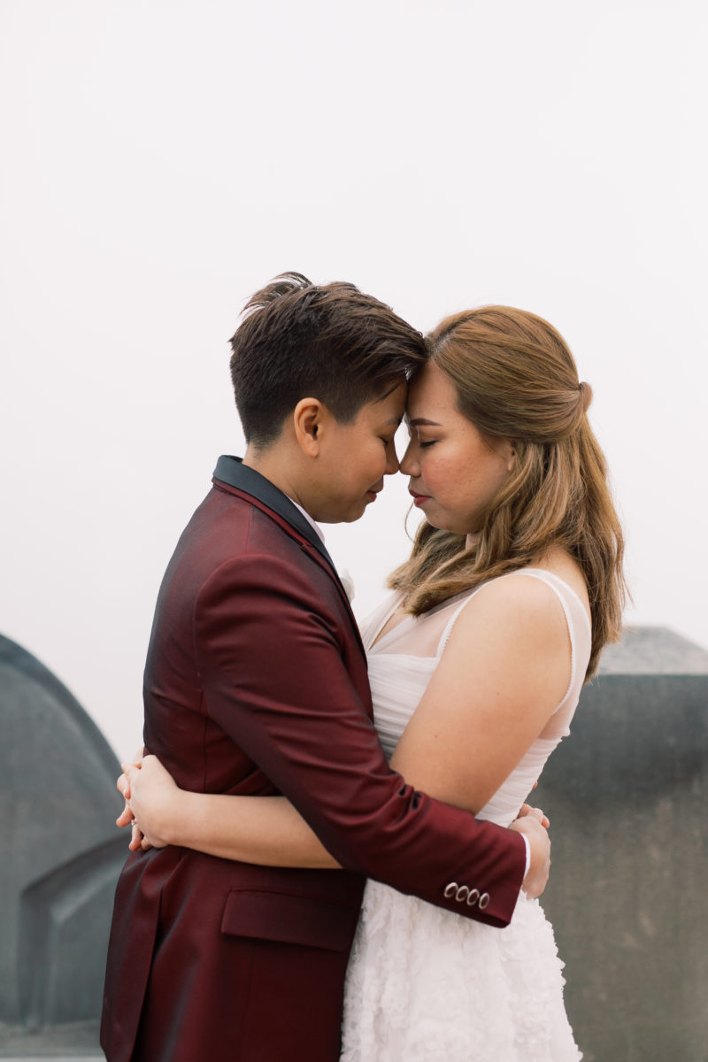 Romantic spring elopement at The Top of The Rock in New York City wine cranberry suit white dress New York City NYC two brides LGBTQ+ weddings lesbian gay wedding transcontinental destination