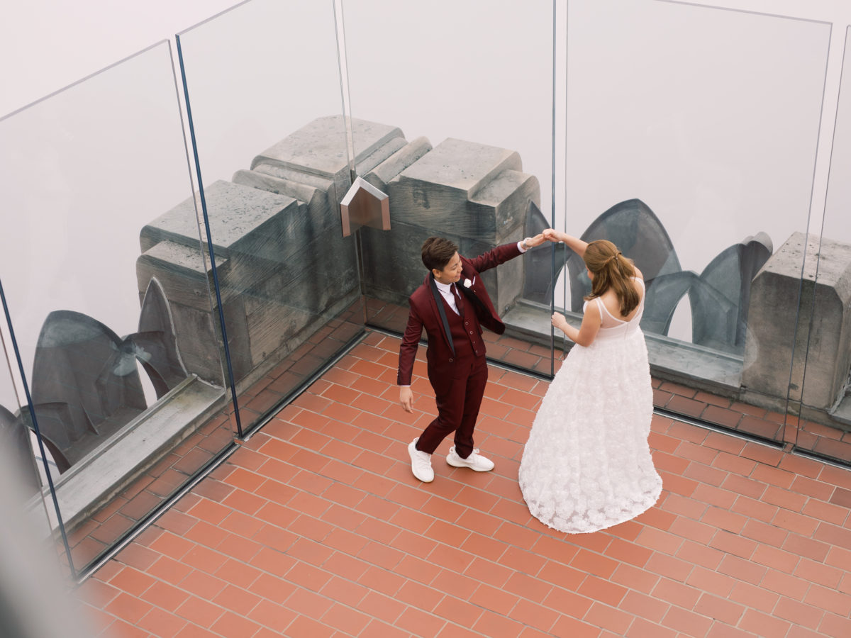 Romantic spring elopement at The Top of The Rock in New York City wine cranberry suit white dress New York City NYC two brides LGBTQ+ weddings lesbian gay wedding transcontinental destination dancing