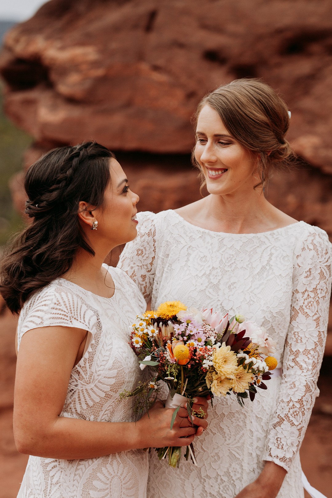 Epic spring Garden of the Gods elopement with dog attendants LGBTQ+ weddings intimate lesbian wedding two brides dogs sandstone formation cliffs bouquet