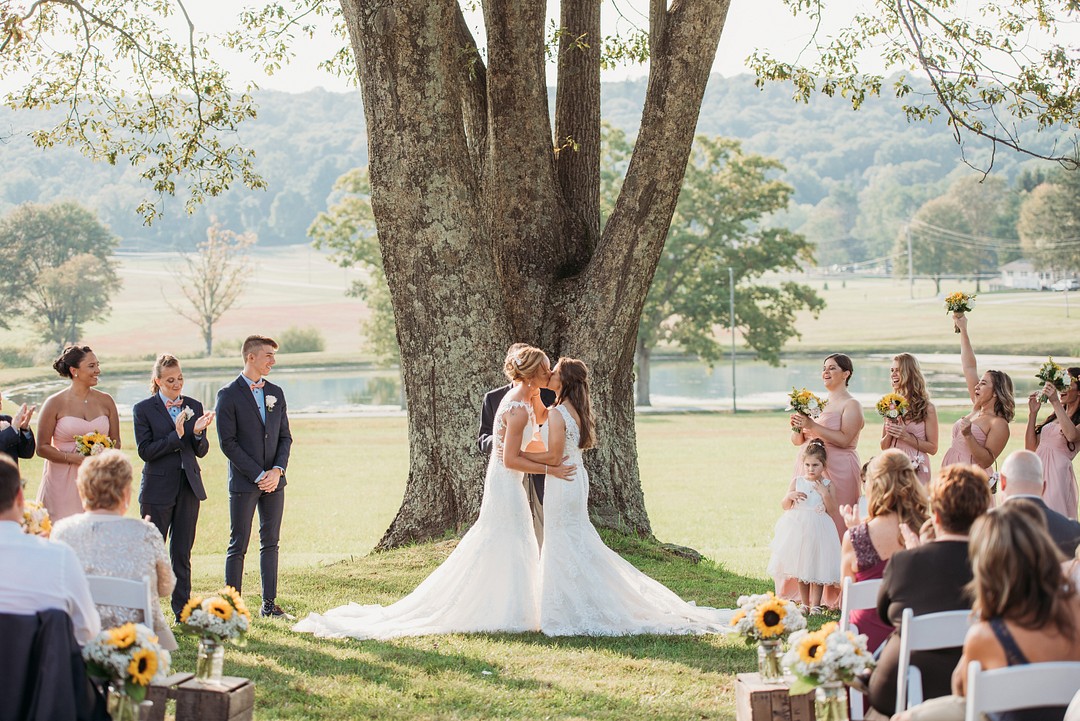 Rustic, elegant early fall wedding in Sabillasville, Maryland LGBTQ+ weddings lesbian wedding two brides long white dresses outdoors South Carolina Southern September wedding sunflowers vows kiss