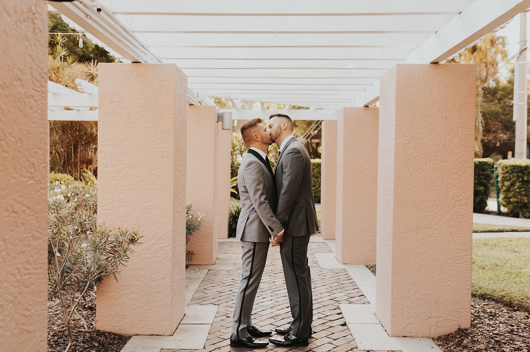 Tropical, timeless wedding in St. Petersburg, Florida LGBTQ+ weddings gay wedding two grooms waterfront kiss