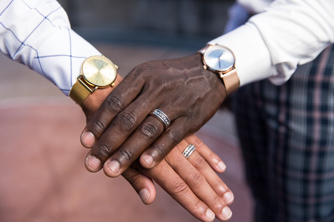 Engagement photos at the Millennium Gate in Atlanta, Georgia LGBTQ+ weddings engagements two grooms museum hands