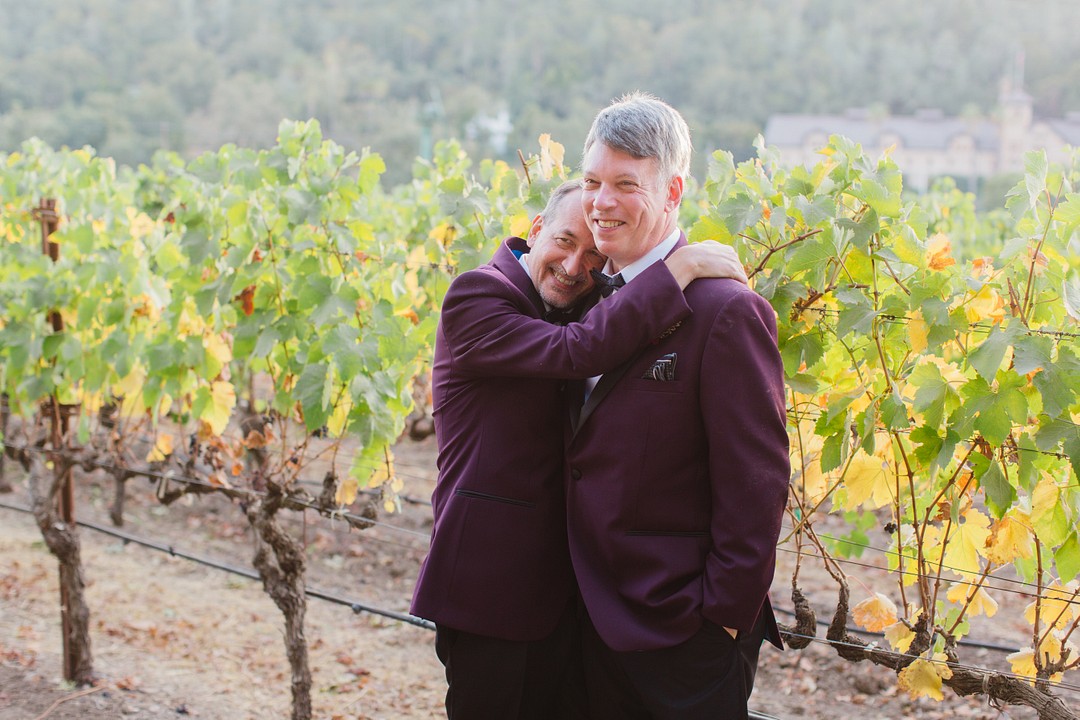 After 20 years, two grooms celebrate with whimsical winery wedding LGBTQ+ weddings aerialist gay wedding purple tux gold glitter tux fall California wedding wine country