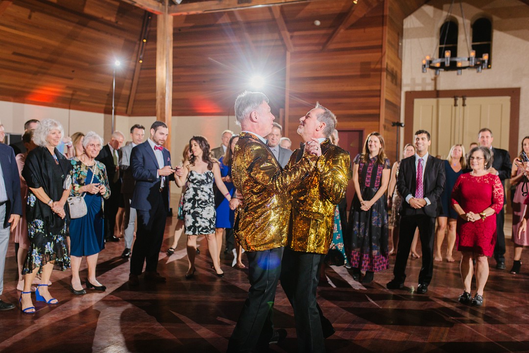 After 20 years, two grooms celebrate with whimsical winery wedding LGBTQ+ weddings aerialist gay wedding purple tux gold glitter tux fall California wedding wine country dance