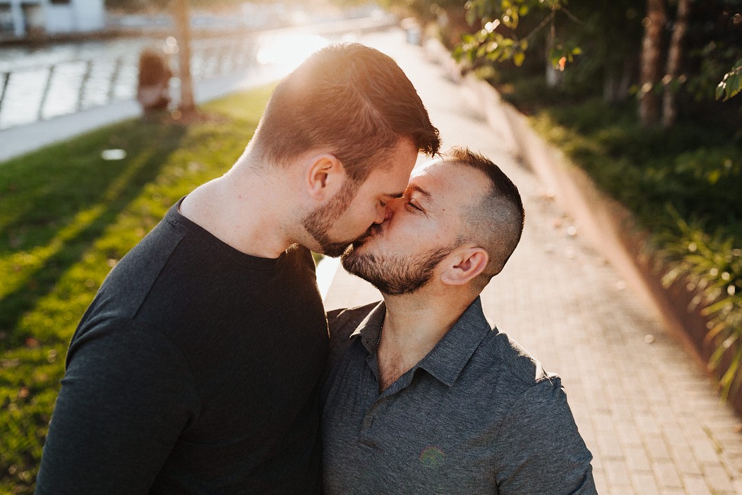 Urban summer engagement photos in Philadelphia, Pennsylvania LGBTQ+ weddings two grooms city engaged kiss