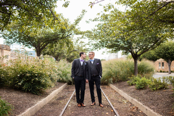 Fall industrial line dancing wedding with colorful touches LGBTQ+ weddings Philadelphia gay wedding two grooms bow ties train tracks