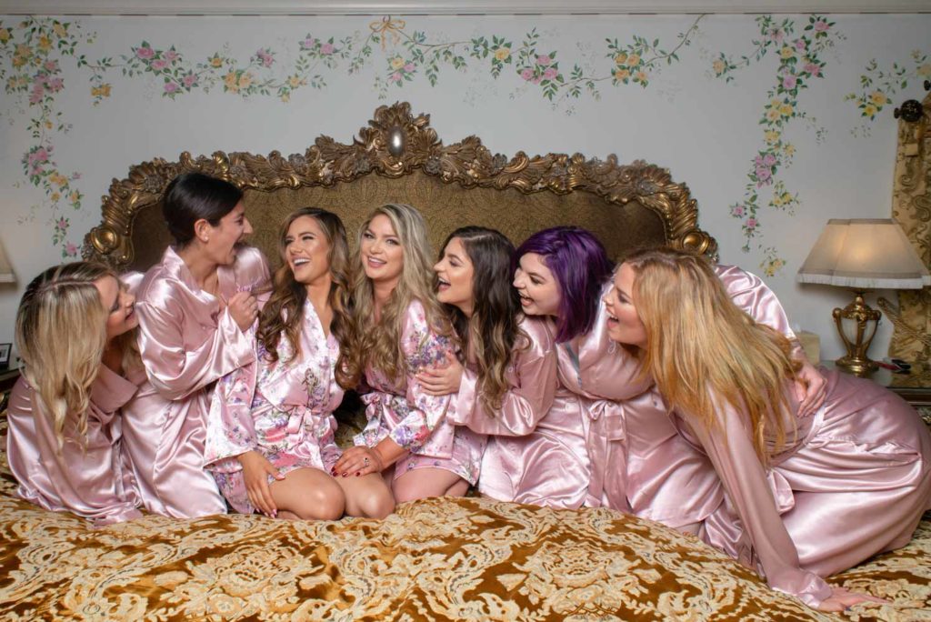 Angelina + Krista: Upscale glamorous lesbian wedding at the renowned Versace mansion in Miami Beach, Florida Suzanne Delawar Studios brides with bridal party in pretty pink robes