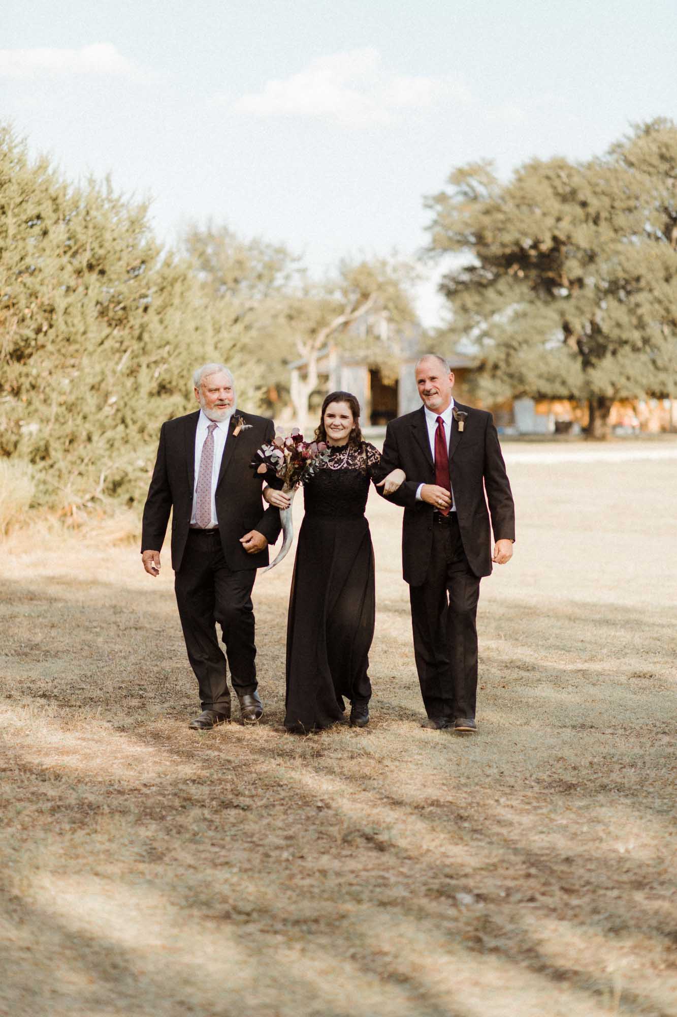 bride with fathers walking down the aisle Beautifully gothic Texas wedding with creative details, photo by Leah Thomason Photography, featured on Equally Wed, the LGBTQ+ wedding magazine