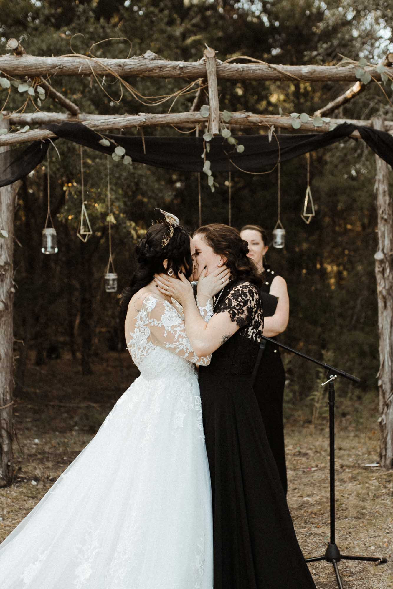 Beautifully gothic Texas wedding with creative details, photo by Leah Thomason Photography, featured on Equally Wed, the LGBTQ+ wedding magazine kiss black wedding dress two brides