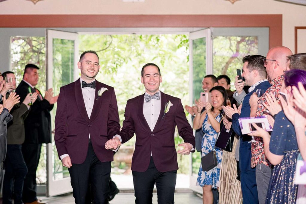 grooms enter wedding reception LGBTQ+ wedding featured on Equally Wed magazine with two grooms Brian + Brett: Hudson Valley garden wedding with shades of purple Upasana Mainali Photography outdoor wedding ceremony