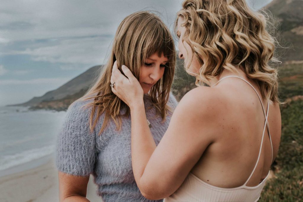 Magical engagement photo session in Big Sur. Photography by Heather K. Purdy. Featured on Equally Wed, the leading LGBTQ+ wedding magazine and wedding vendor directory of LGBTQ+ inclusive wedding pros. pictured: Two women in love kissing on the coast of California