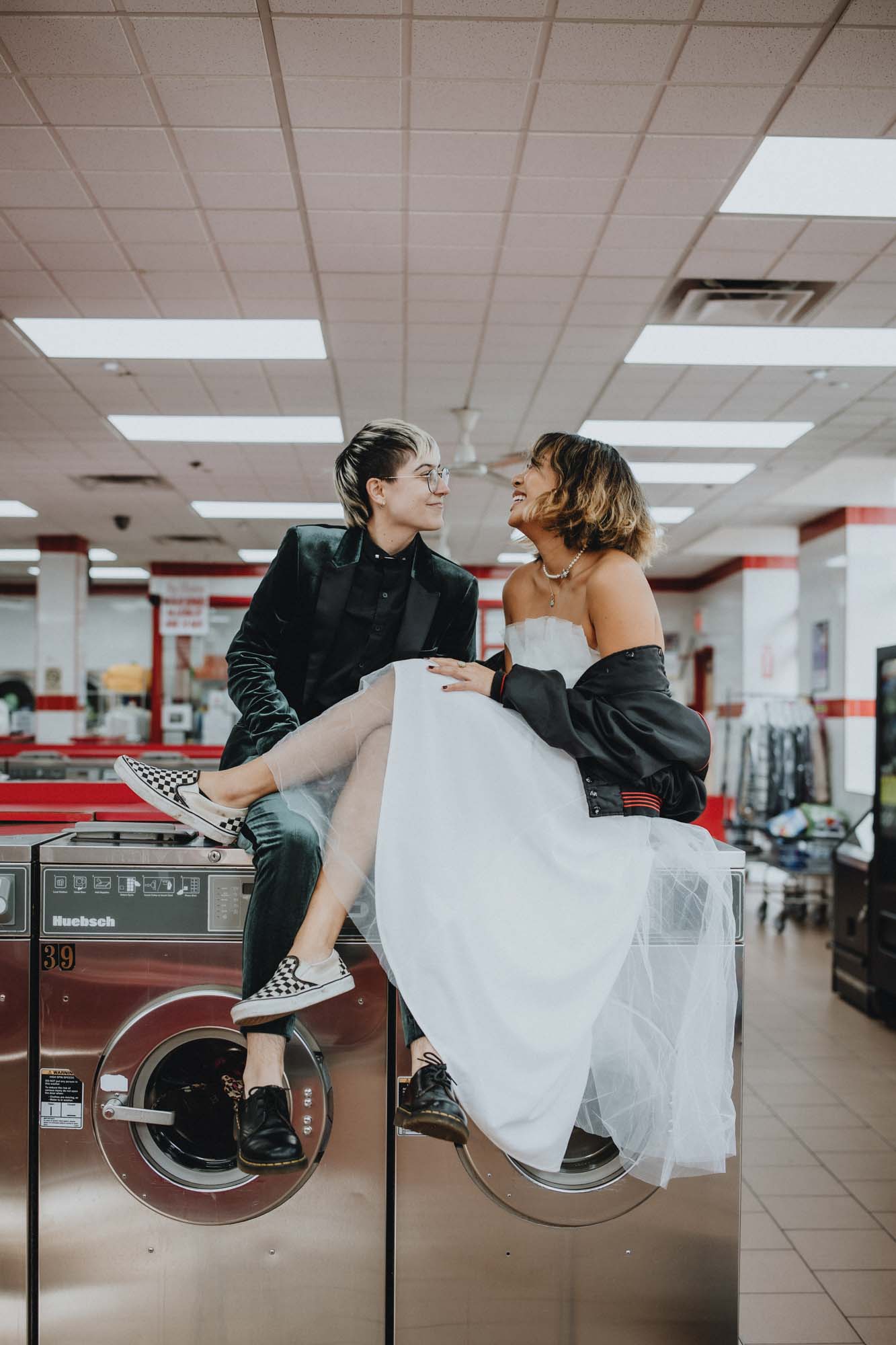 Outdoor Brooklyn microwedding styled shoot | Photography by Lucie B Photography | Featured on Equally Wed, the world's leading LGBTQ+ wedding magazine | LGBTQ+ couple celebrating their wedding with shoot in a laundromat, skateboard, leather jacket