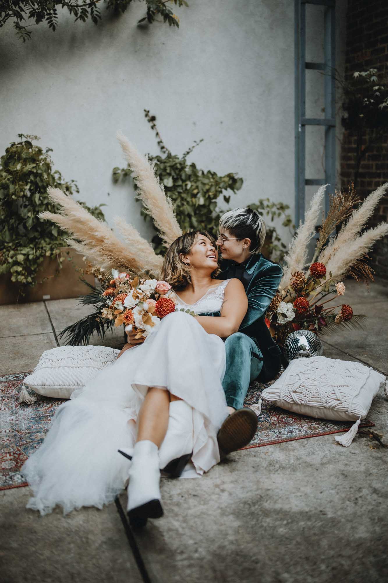 Outdoor Brooklyn microwedding styled shoot | Photography by Lucie B Photography | Featured on Equally Wed, the world's leading LGBTQ+ wedding magazine | LGBTQ+ marriers relax on Boho decor after saying I do