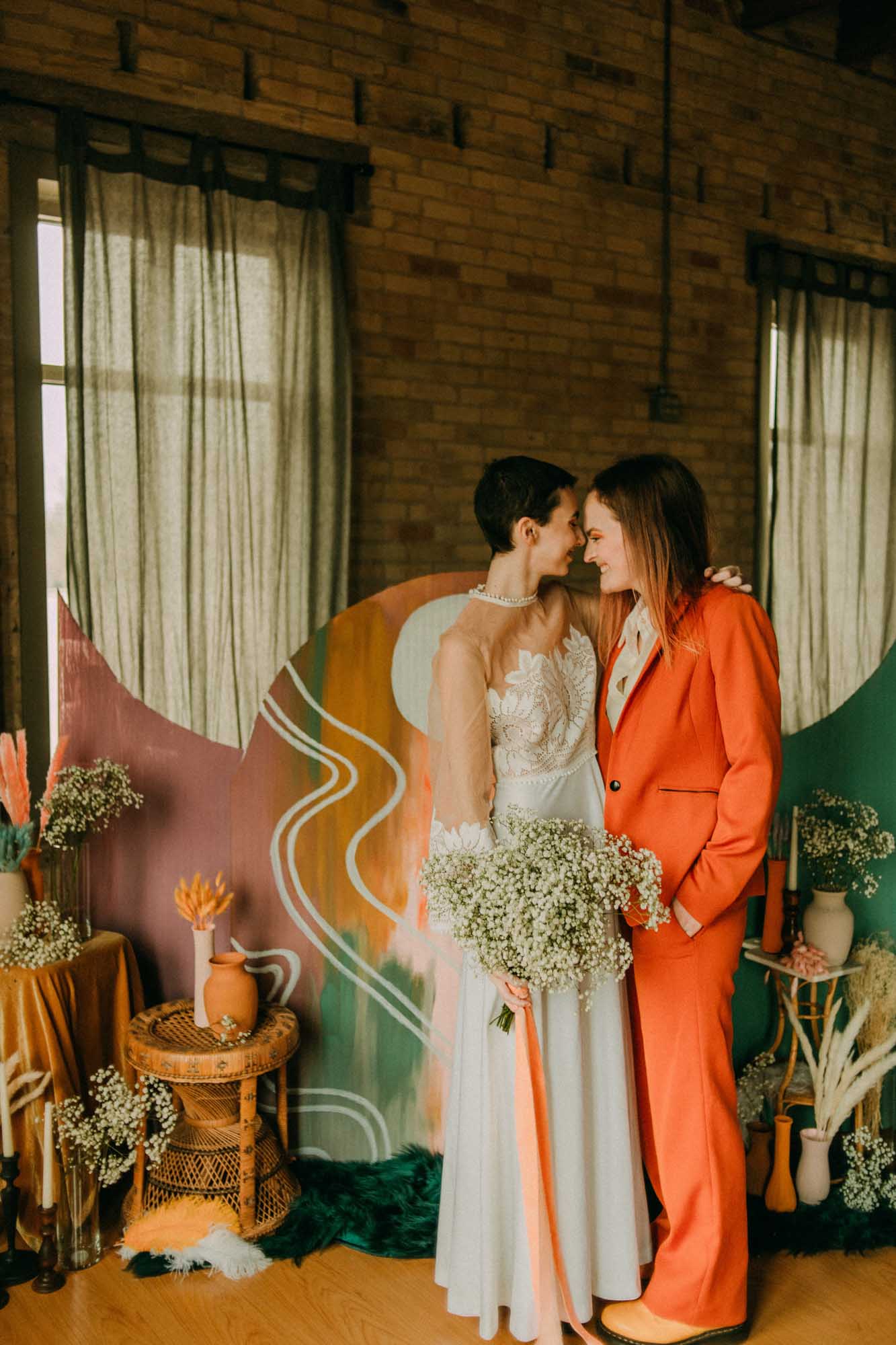 Colorful wedding inspiration with funky rainbow backdrop and bold orange suit | A, Lentz Photography | Featured on Equally Wed, the leading LGBTQ+ wedding magazine
