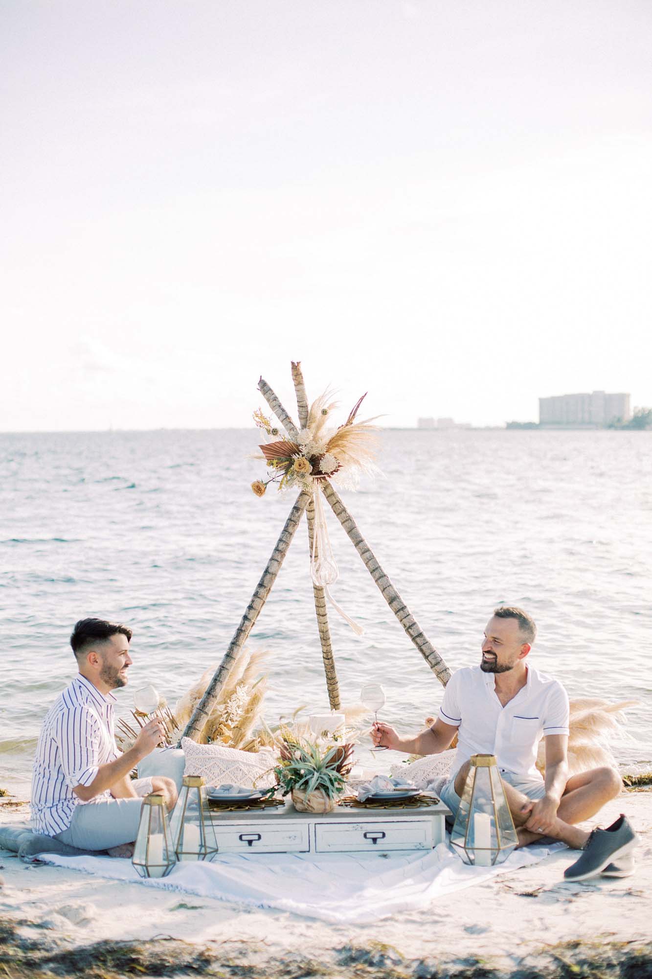 Seaside engagement inspiration with picnic, classic car, and handmade floral masks | Erica J Photography | Featured on Equally Wed, the leading LGBTQ+ wedding magazine