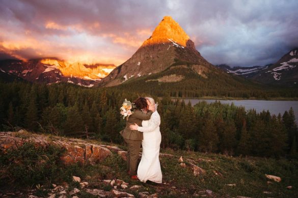 Glowing sunset wedding in Glacier National Park | Jessica Billings Photography | Featured on Equally Wed, the leading LGBTQ+ wedding magazine - mountain, sunset, white dress, green suit