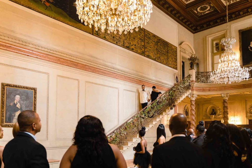 This couple transformed their home into a fabulous wedding venue | Myron Fields Photography | Featured on Equally Wed, the leading LGBTQ+ wedding magazine - chandelier, grand staircase