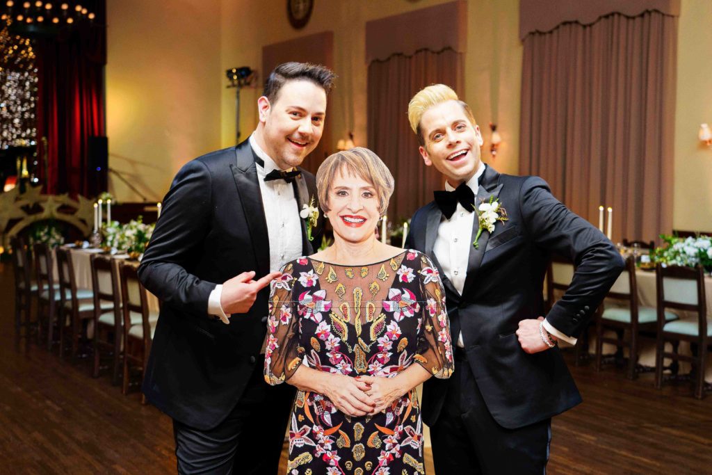 grooms pose with cardboard cutout of Patti LuPone