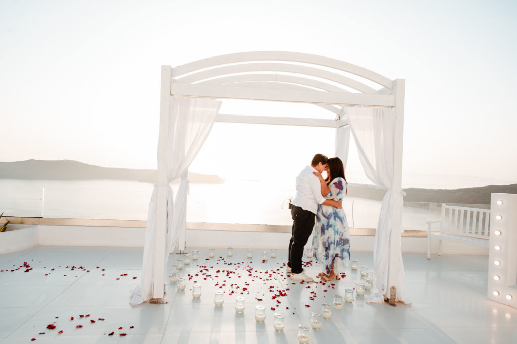 Breathtaking Santorini proposal with rose petals and a heart made of candles | Santorini Proposals | Featured on Equally Wed, the leading LGBTQ+ wedding magazine